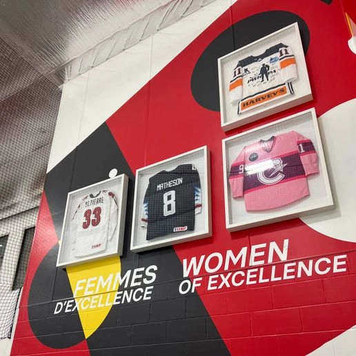 Women of excellence wall at Hockey Etcetera with 4 jerseys framed hanging on it